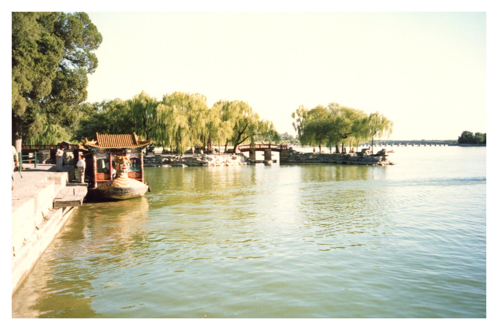 A still lake at the Summer Palace, with willows and a small boat